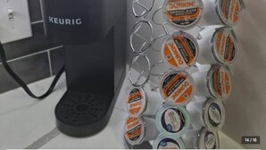 Une machine à café Keurig et un distributeur en métal rempli de capsules de café Dunkin'.