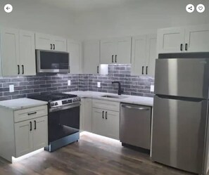 A modern kitchen with light-colored cabinets, a stainless steel refrigerator, a built-in oven, and a microwave. - The Macro-Lux at Lower Atwells 2BR APT Ldry.DW "P" (Providence)