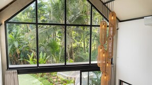 A modern interior with a large window, a ceiling fan, and a wooden coffee table. - Sava Villa Ubud Rice Fields View (Ubud)