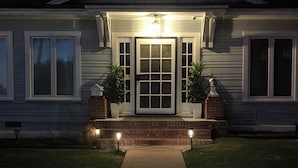 A residential house with a front porch, a central door, and two potted plants on either side. - La Jolla White Door Cottage walking distance to beach, cove, shops, &restaurants (La jolla)