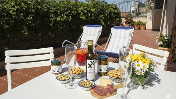 Une table dressée à l’extérieur, avec de la nourriture, des boissons et une bouteille de vin.