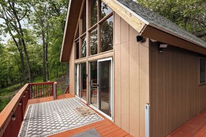 A wooden cabin with a deck, large windows, and a view of the forest. - Stunning Mountain Views w/Deck & Grill on 5 Acres! (Slanesville)