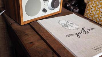 A framed radio on a wooden surface with a visitor guest book beside it.