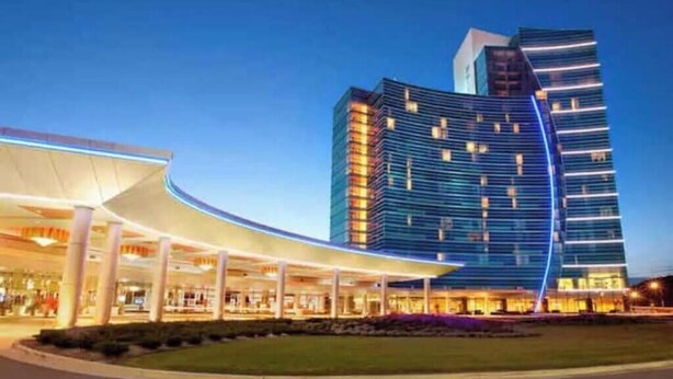 A modern hotel with a curved entrance and a high-rise building in the background.