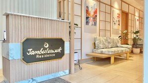 Un comptoir d’accueil avec une pancarte indiquant « Résidence Jambuluwet ».