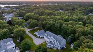 A large, two-story house with a spacious front yard and a driveway. - 7BR Estate · One Block to Ocean · Sleeps 22 (Falmouth)