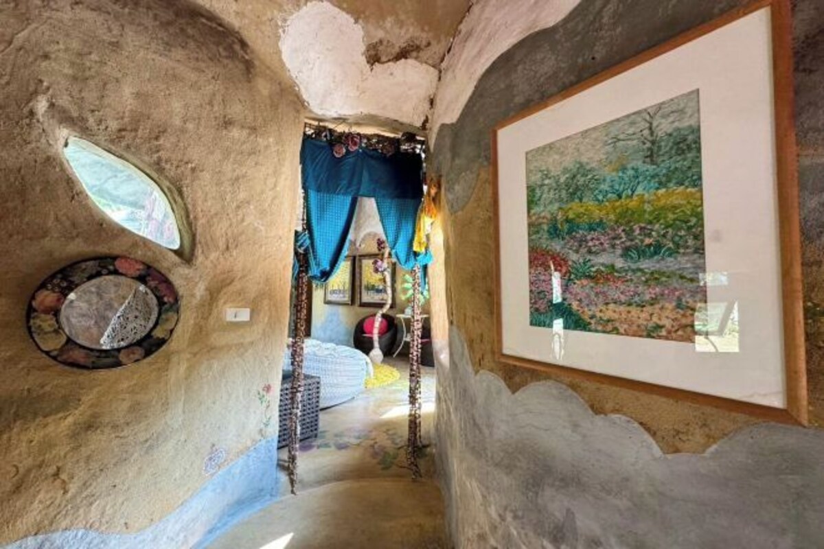 Un interior rústico y estrecho con una escalera que lleva a un dormitorio.