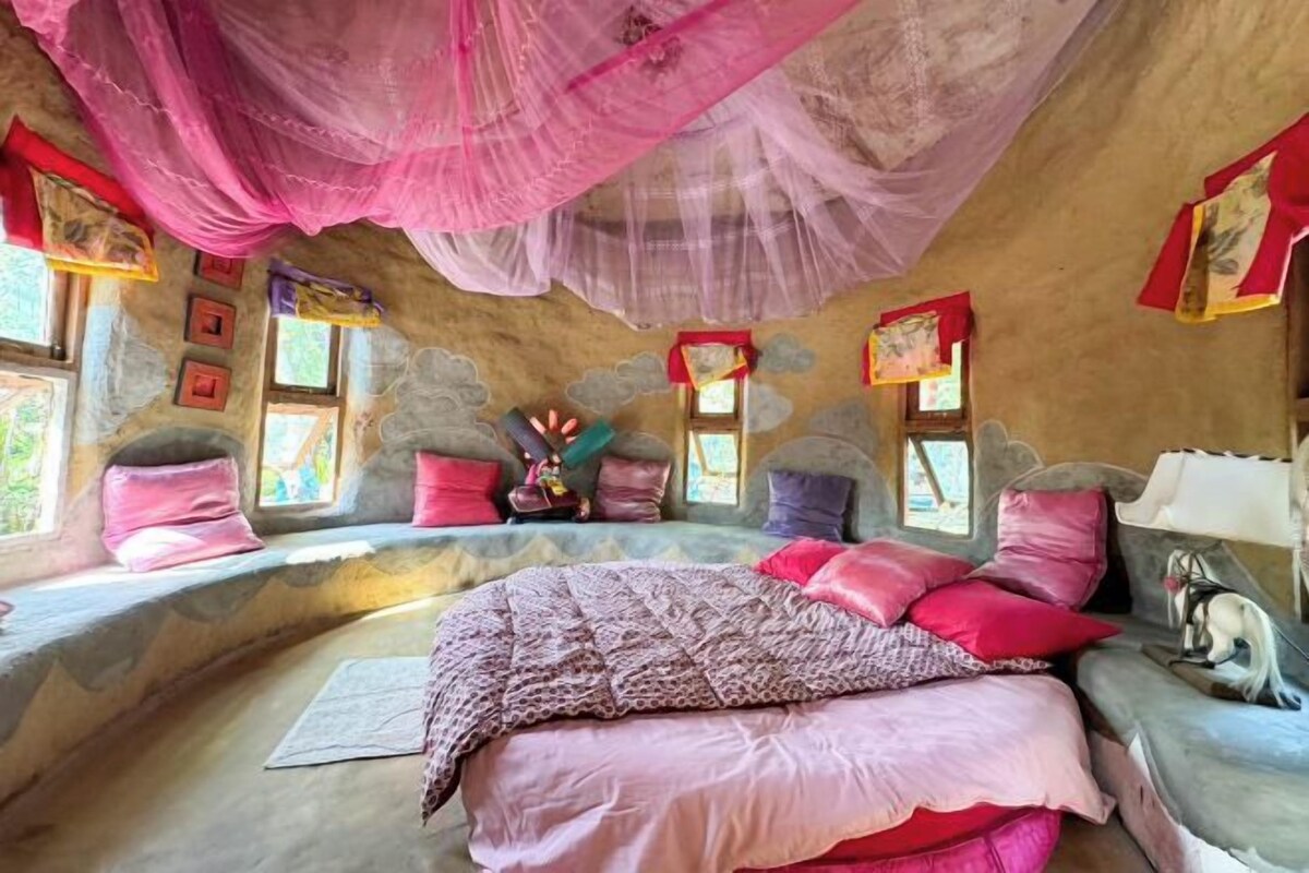 A cozy bedroom with a bed, pillows, and a canopy.