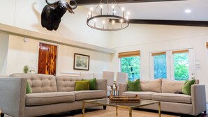 A spacious living room with two sofas, a coffee table, and a mounted buffalo head.