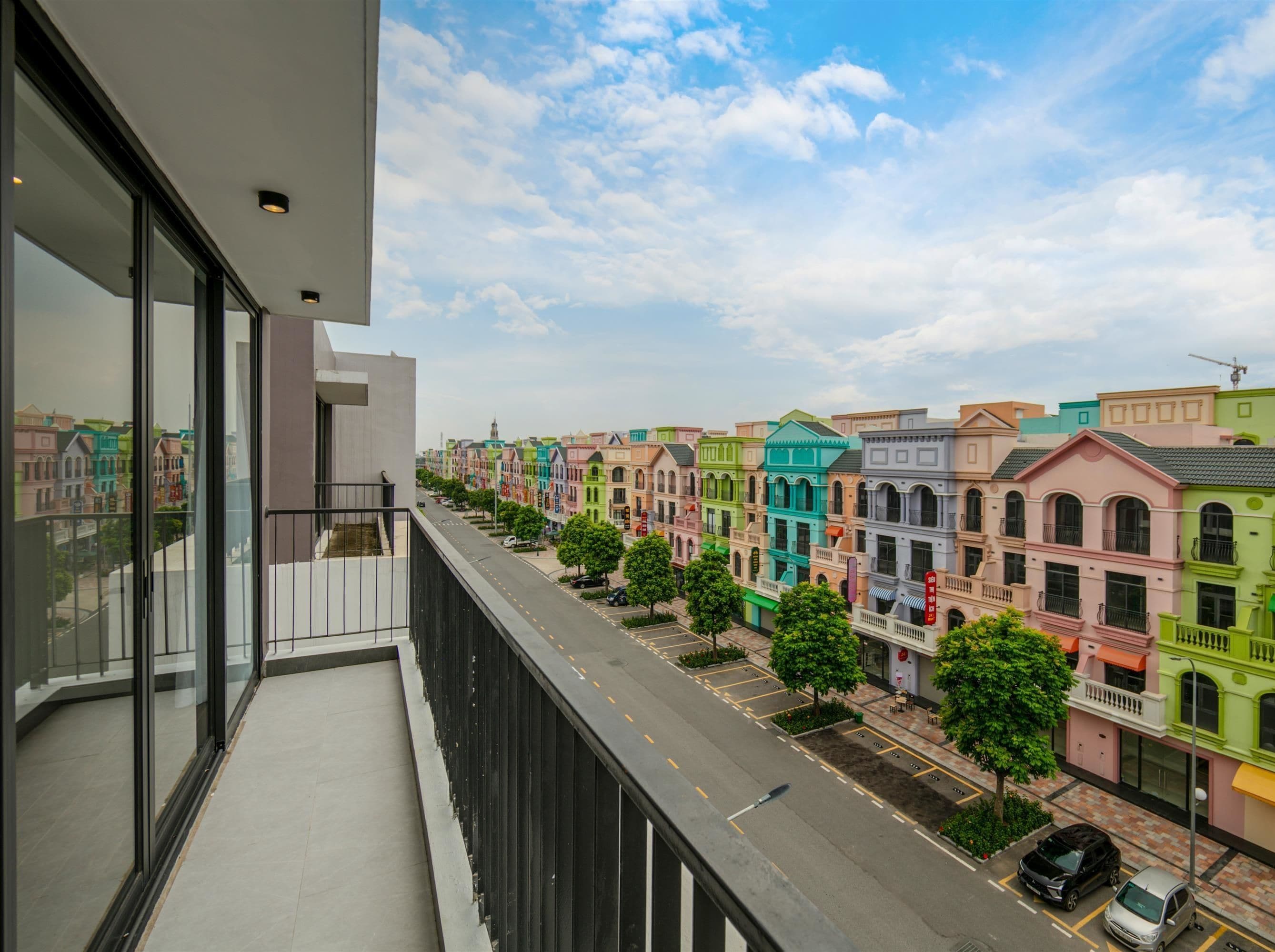 A balcony with a view of colorful townhouses and a clear sky.