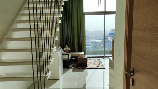 A modern interior with a staircase, a sofa, and a view of the city. - Cozy Duplex Loft with WiFi and AC in amazing Gurugram (Gurugram)