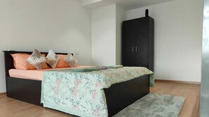 A bedroom with a bed, a wardrobe, and a rug. - Cozy Duplex Loft with WiFi and AC in amazing Gurugram (Gurugram)