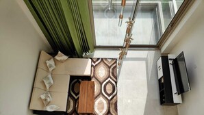 A compact living space with a sofa, patterned rug, and a built-in cabinet. - Cozy Duplex Loft with WiFi and AC in amazing Gurugram (Gurugram)