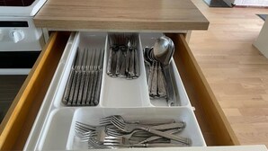 Un cajón de cocina con utensilios.
