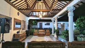 Una habitación amplia con techo de madera, un candelabro, un ventanal y vistas al exterior.
