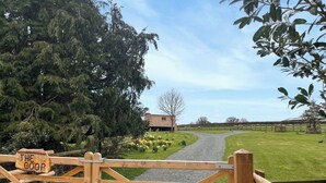 A wooden gate with a sign reading 'THE COOP' leading to a grassy area with a building in the background. - 1 bedroom accommodation in Southtown, nr Illminster (Southtown, nr Illminster)