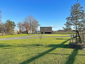 Une propriété rurale comprenant un chalet en bois, un pâturage clôturé et un ciel dégagé.