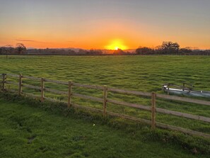 A grassy field with a wooden fence and a metal structure.