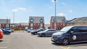 A parking lot with multiple cars and a building with a red brick facade.