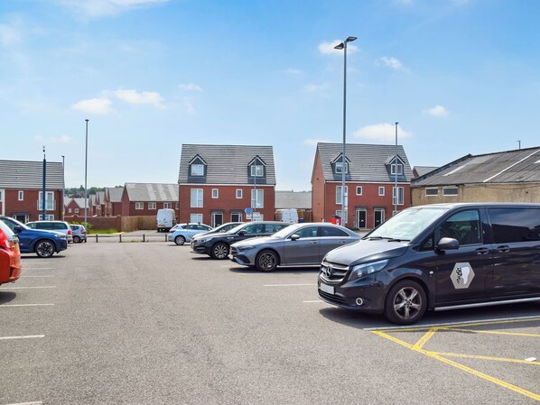 A parking lot with multiple cars and a building with a red brick facade.