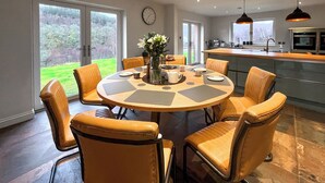 Una cocina moderna con una mesa redonda, sillas y vistas al exterior.