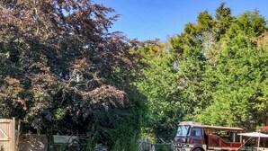 A vintage bus parked in a grassy area with trees in the background. - 1 bedroom accommodation in Hailsham (Hailsham)