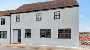 A two-story building with a white facade and a tiled roof.