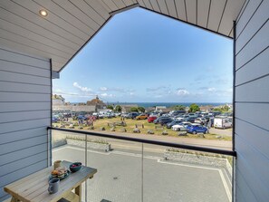 Ein Balkon mit Blick auf einen Parkplatz und Gebäude.