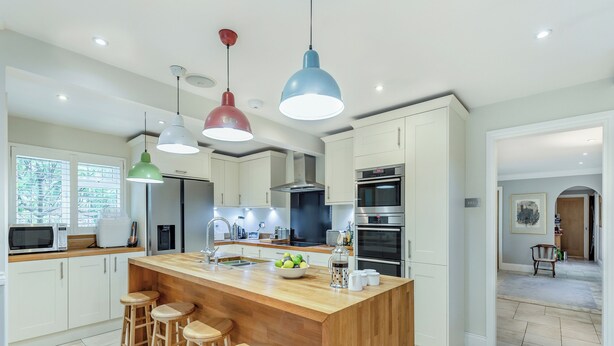 A modern kitchen with a central island, bar stools, and a view into the dining area. - 2 bedroom accommodation in Penn (Penn)
