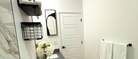Een moderne badkamer met toilet, wastafel en handdoekhouder.
