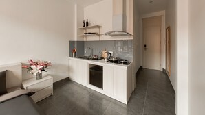 Una cucina moderna con mobili bianchi, forno a incasso e cappa aspirante in acciaio inossidabile.