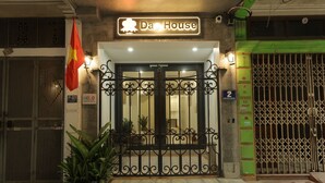 L'ingresso di un edificio con un cartello che riporta 'Dao House', un cancello in metallo e una bandiera.