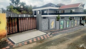 A modern two-story building with a stone facade and a red roof. - Madhurai Resort (Chikhaldara)