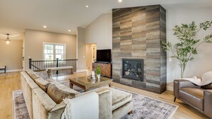 A spacious living room with a large sofa, a coffee table, and a fireplace. - Walk to Beaches + Restaurants: Elkhart Lake Escape (Elkhart Lake)