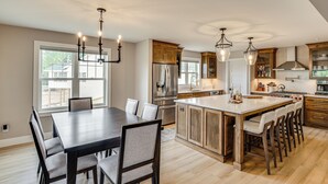 A spacious kitchen with a large island, wooden cabinets, and modern appliances. - Walk to Beaches + Restaurants: Elkhart Lake Escape (Elkhart Lake)