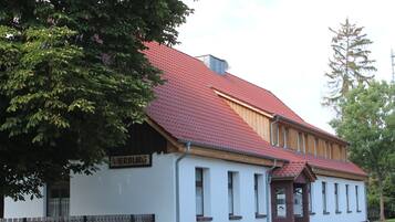 Rakennuksessa on punainen katto, sen edessä on puinen aita ja sen yläpuolella on kyltti, jossa lukee »VIERBURG».