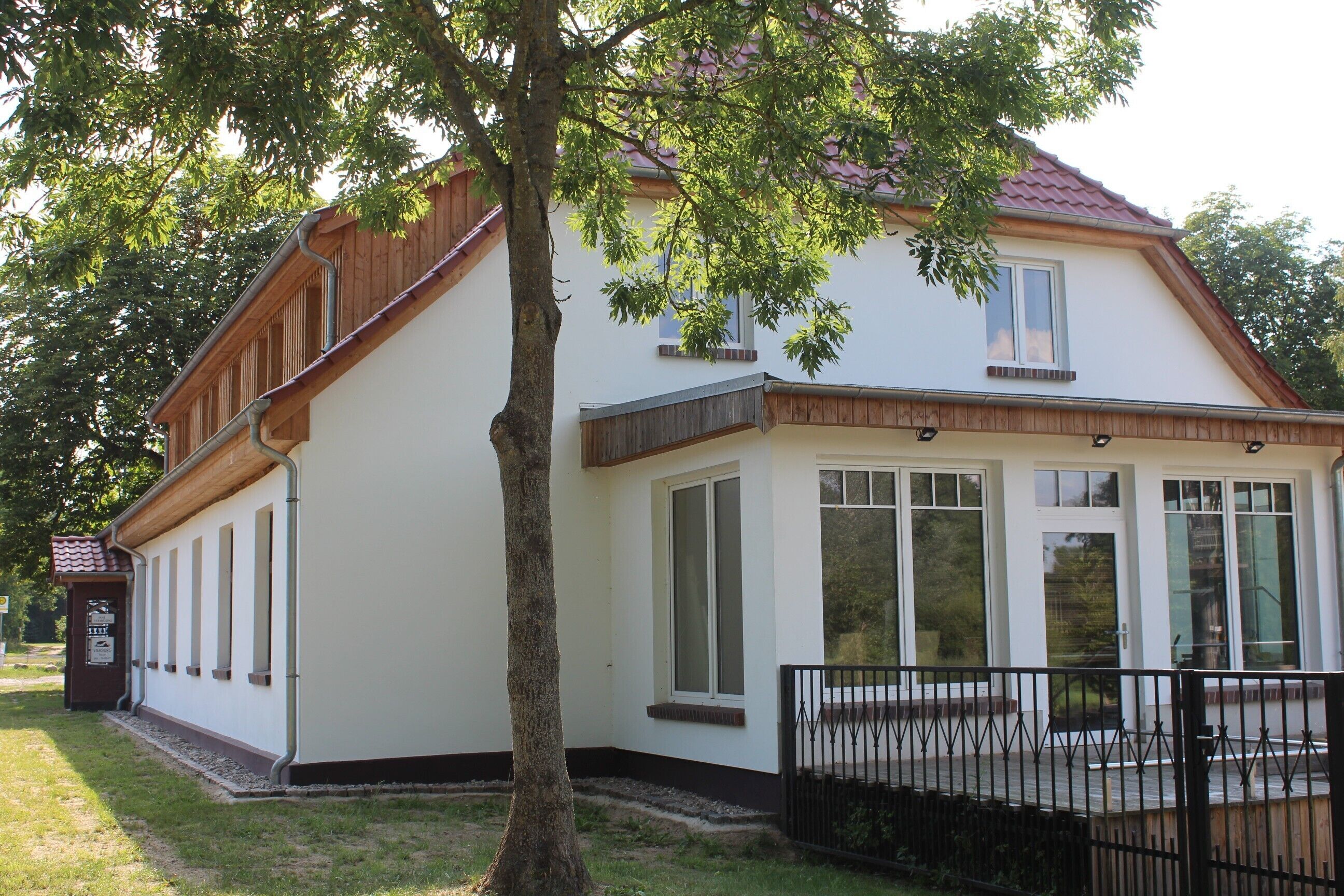 A two-story building with a white exterior, large windows, and a red roof.
