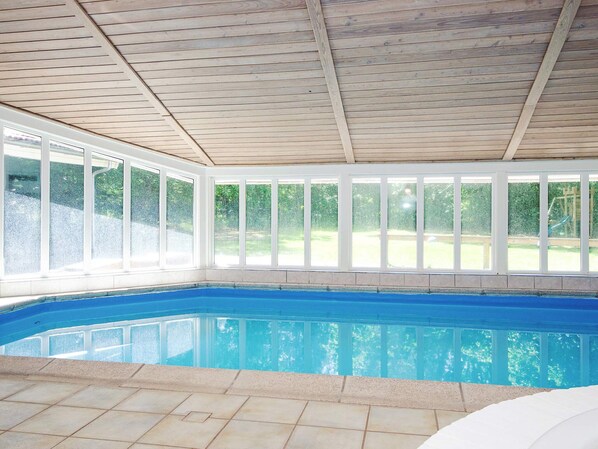 An indoor swimming pool with a wooden ceiling and large windows. - 4 Star Holiday Home in Vig (Vig)
