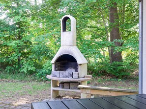 A stone-built outdoor pizza oven with a chimney, surrounded by greenery. - 4 Star Holiday Home in Vig (Vig)