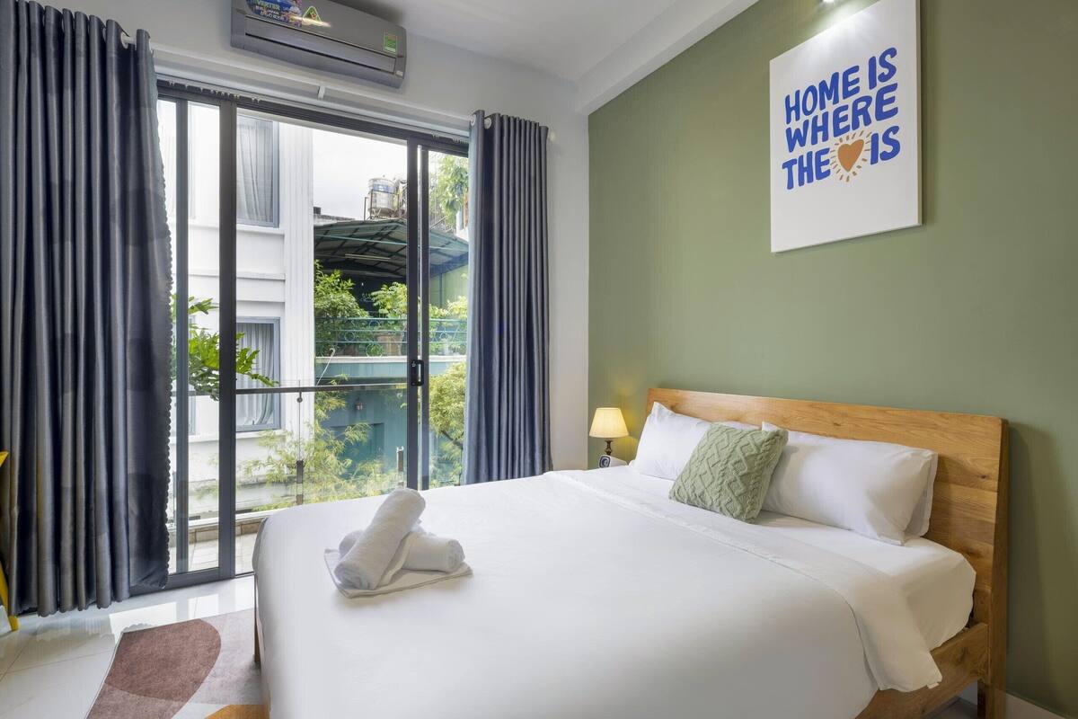 Une chambre d’hôtel avec un grand lit, une vue sur l’extérieur et un panneau accroché au mur.