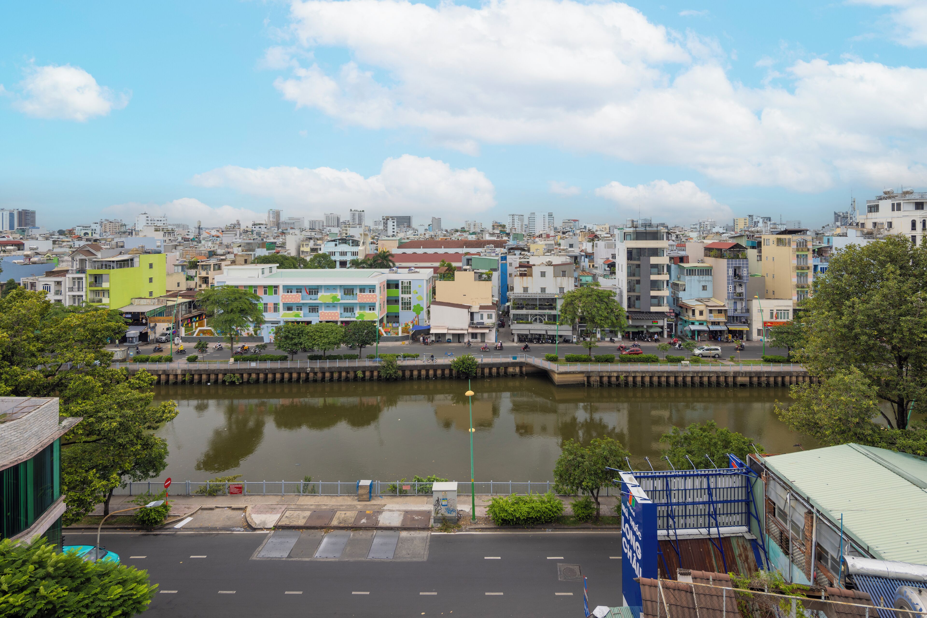 A cityscape with a river, buildings, and a parking lot.