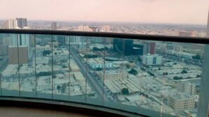 Een panoramisch uitzicht vanaf een hoog gebouw, met een stadsgezicht vol gebouwen en wegen.