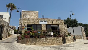 Edificio de piedra con un letrero que dice 'Art & Crafts' y un balcón con plantas en macetas.