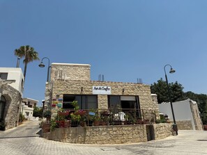 A stone building with a sign for 'Art & Crafts' and a balcony with potted plants.