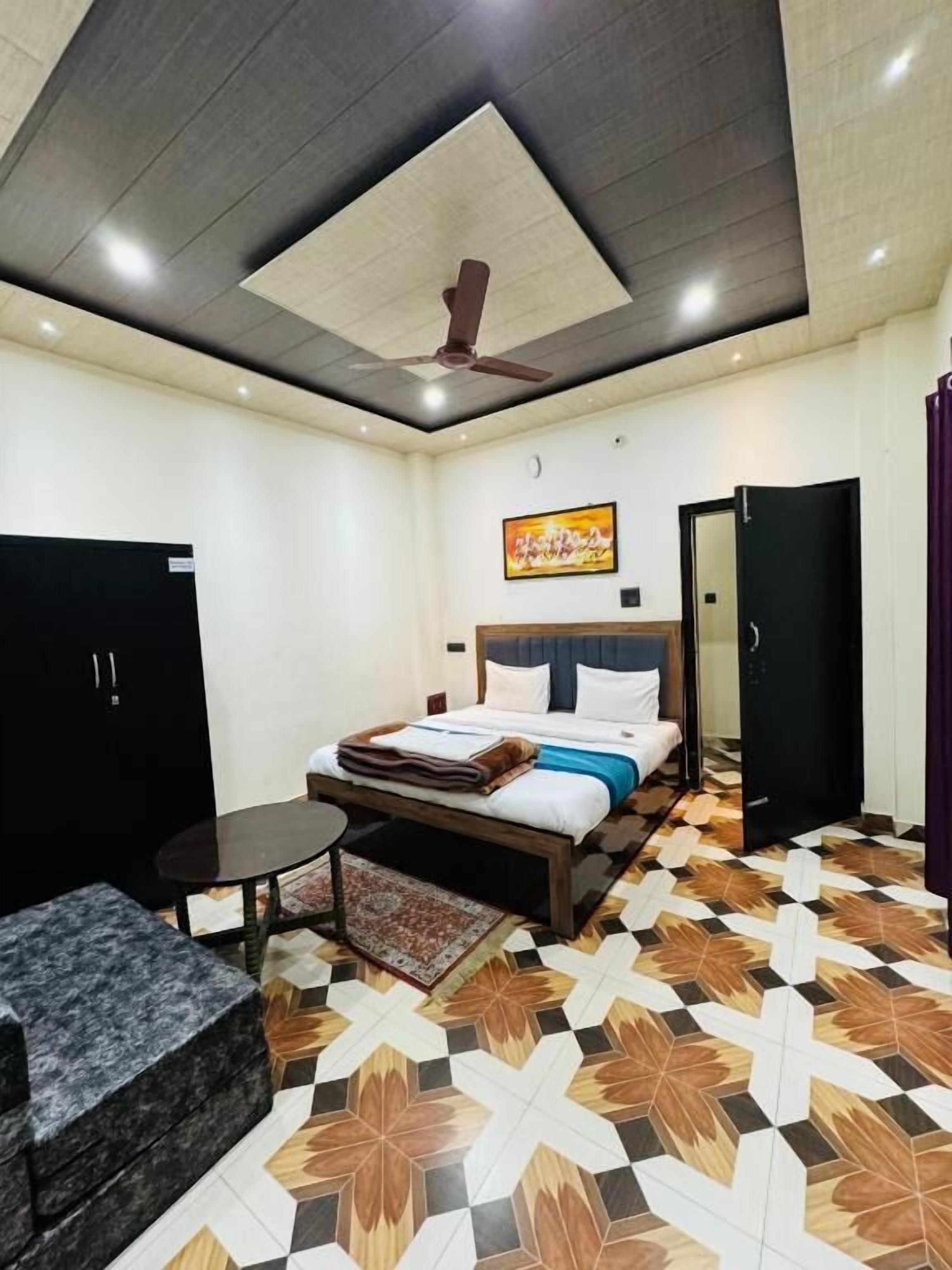 A bedroom with a bed, a desk, a wardrobe, and a ceiling fan.