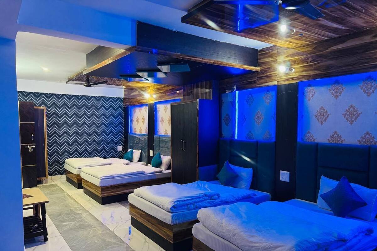 A modern hotel room with two beds, a desk, and a wardrobe.