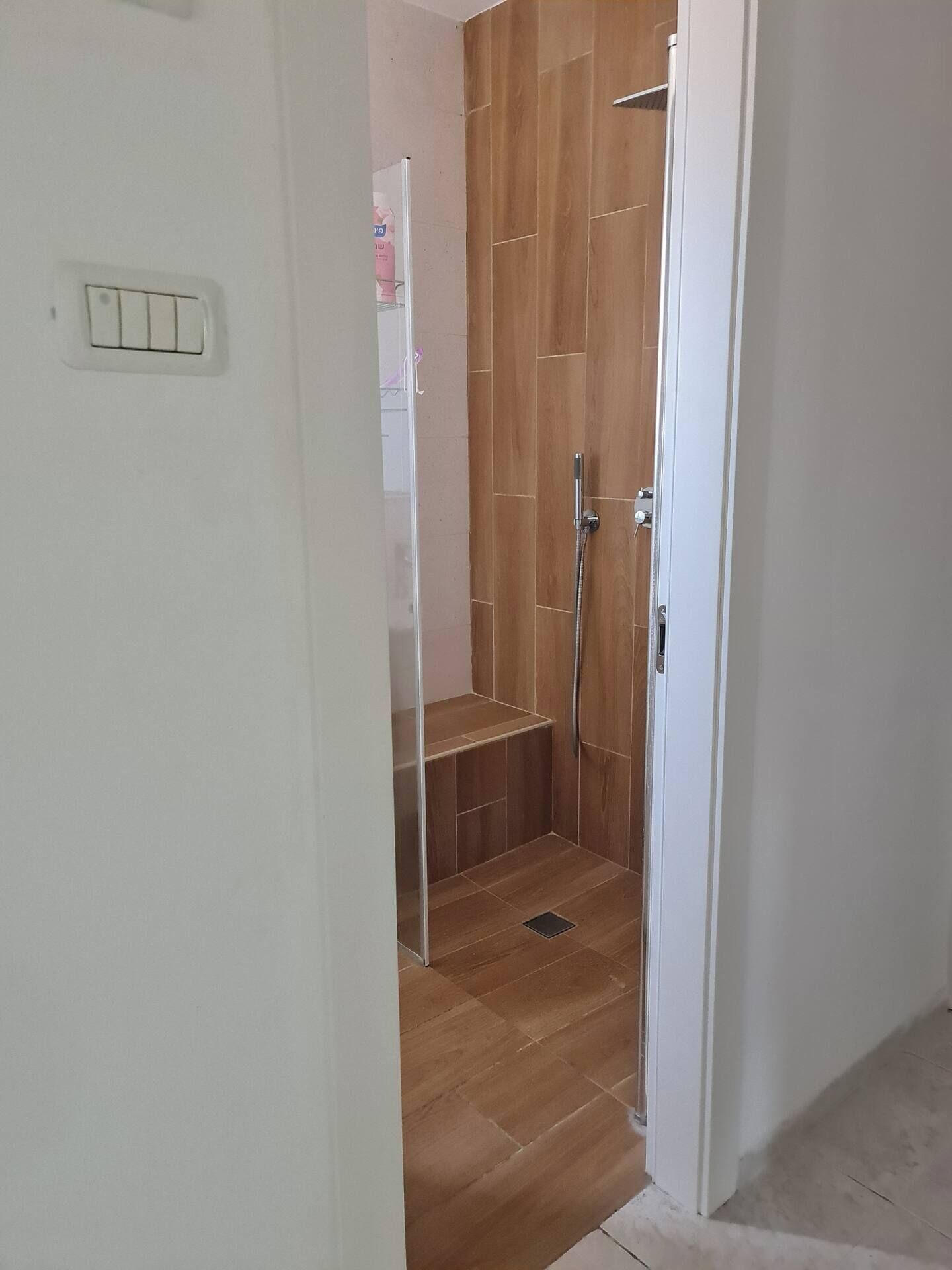 Ein Duschbereich mit Holzboden und einer Metall-Dusche.