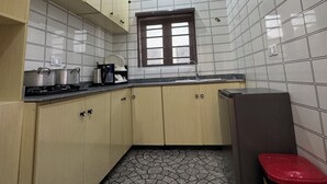 Une cuisine de taille réduite avec des murs carrelés, une fenêtre et un sol à motifs.