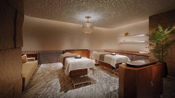 Een spa-ruimte met twee massagetafels, een houten kast en een decoratief plafond.