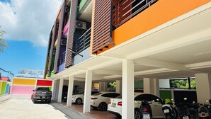 A multi-story parking garage with a white car and a truck parked inside. - Rainbow Room No.13 Front of Haad Rin (Koh Samui)
